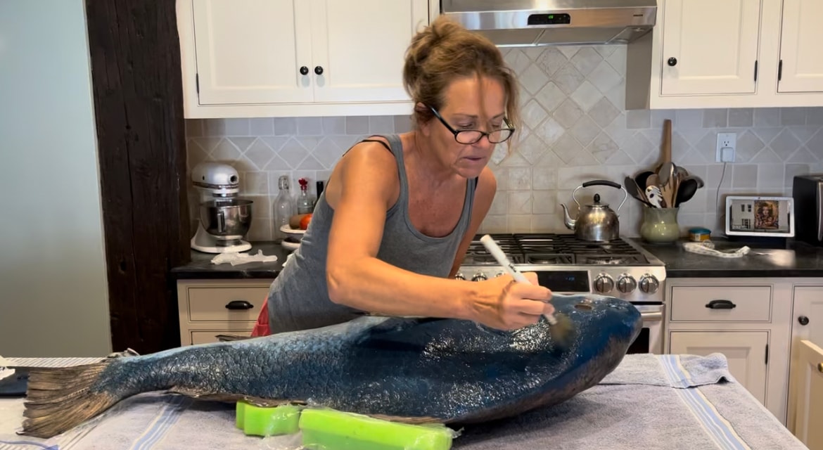 Bridget cleaning a large fish on the kitchen counter